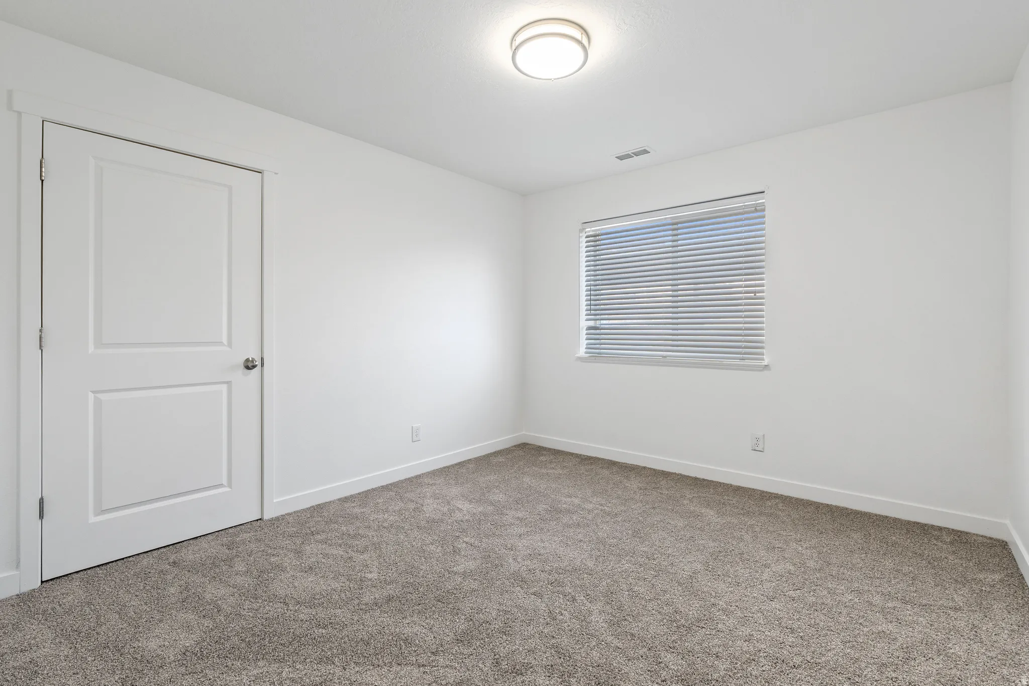 Spare room featuring carpet flooring and baseboards