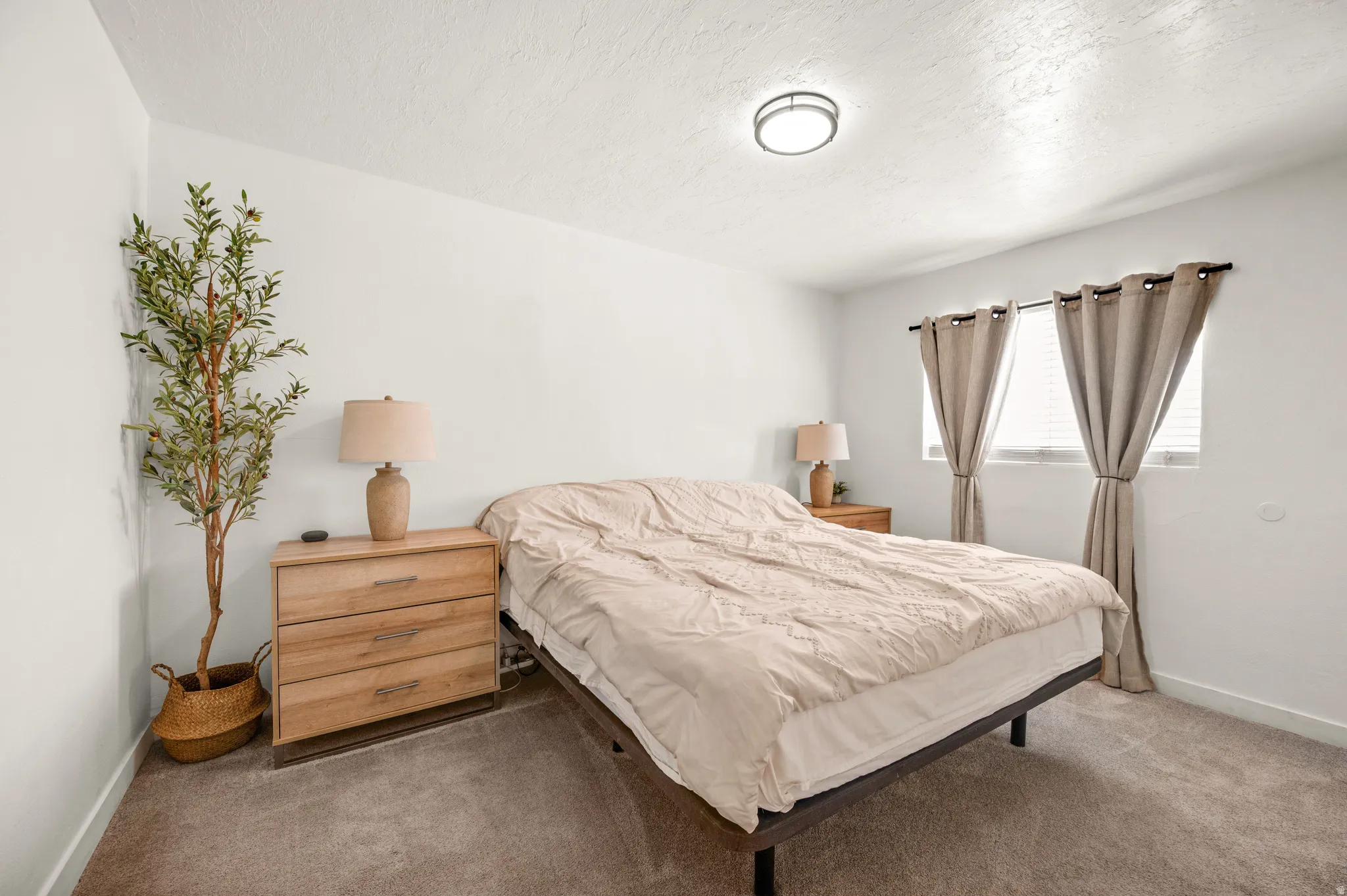 Carpeted bedroom featuring baseboards and a textured ceiling