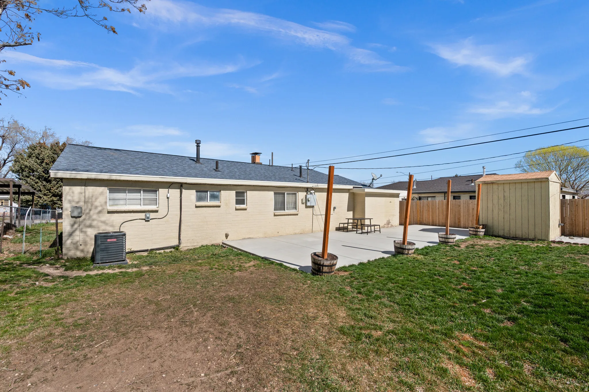 Back of property featuring a fenced backyard, a patio, a shed, and roof with shingles