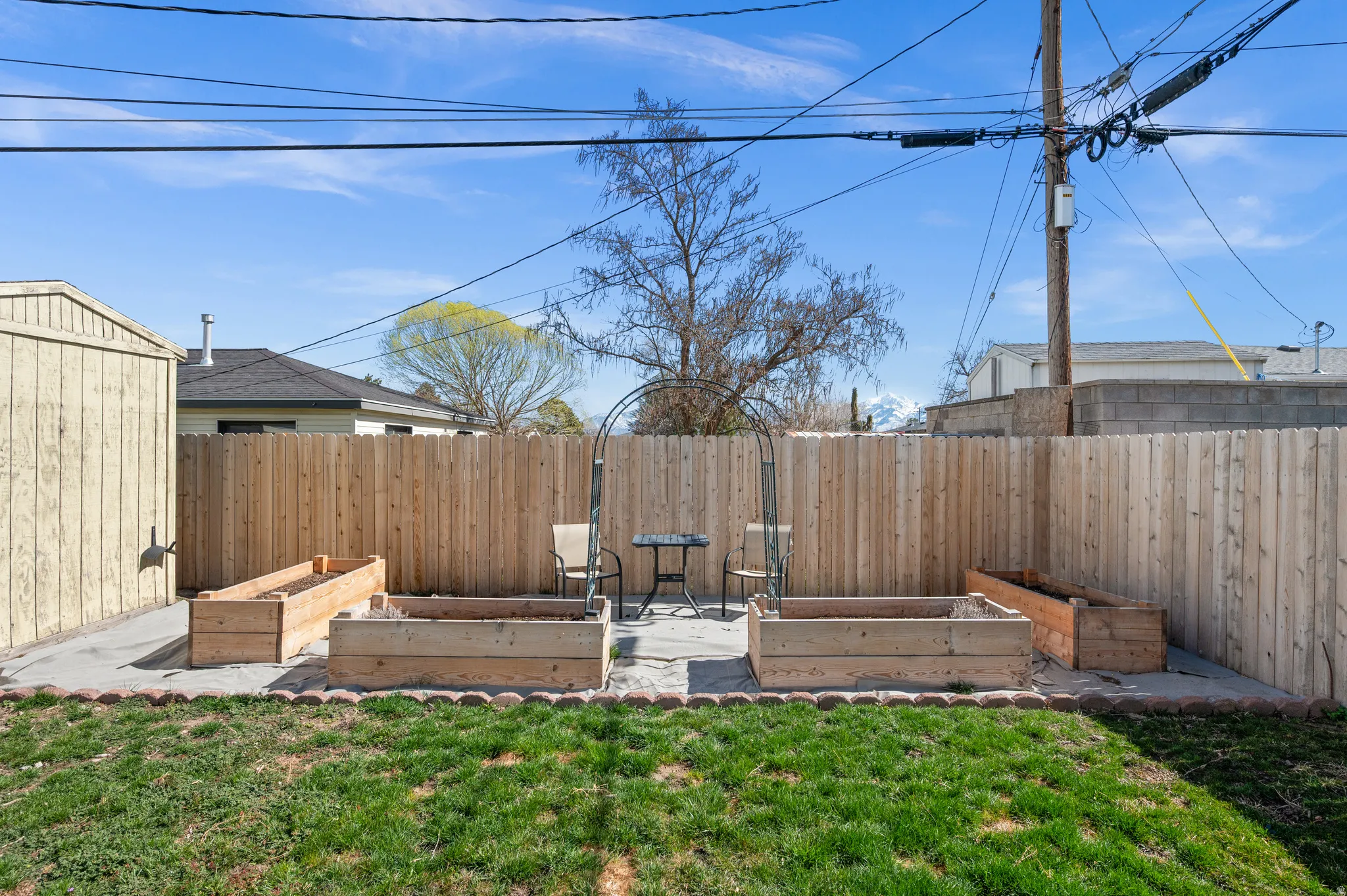 Fenced backyard featuring a garden, a patio area, and a storage shed