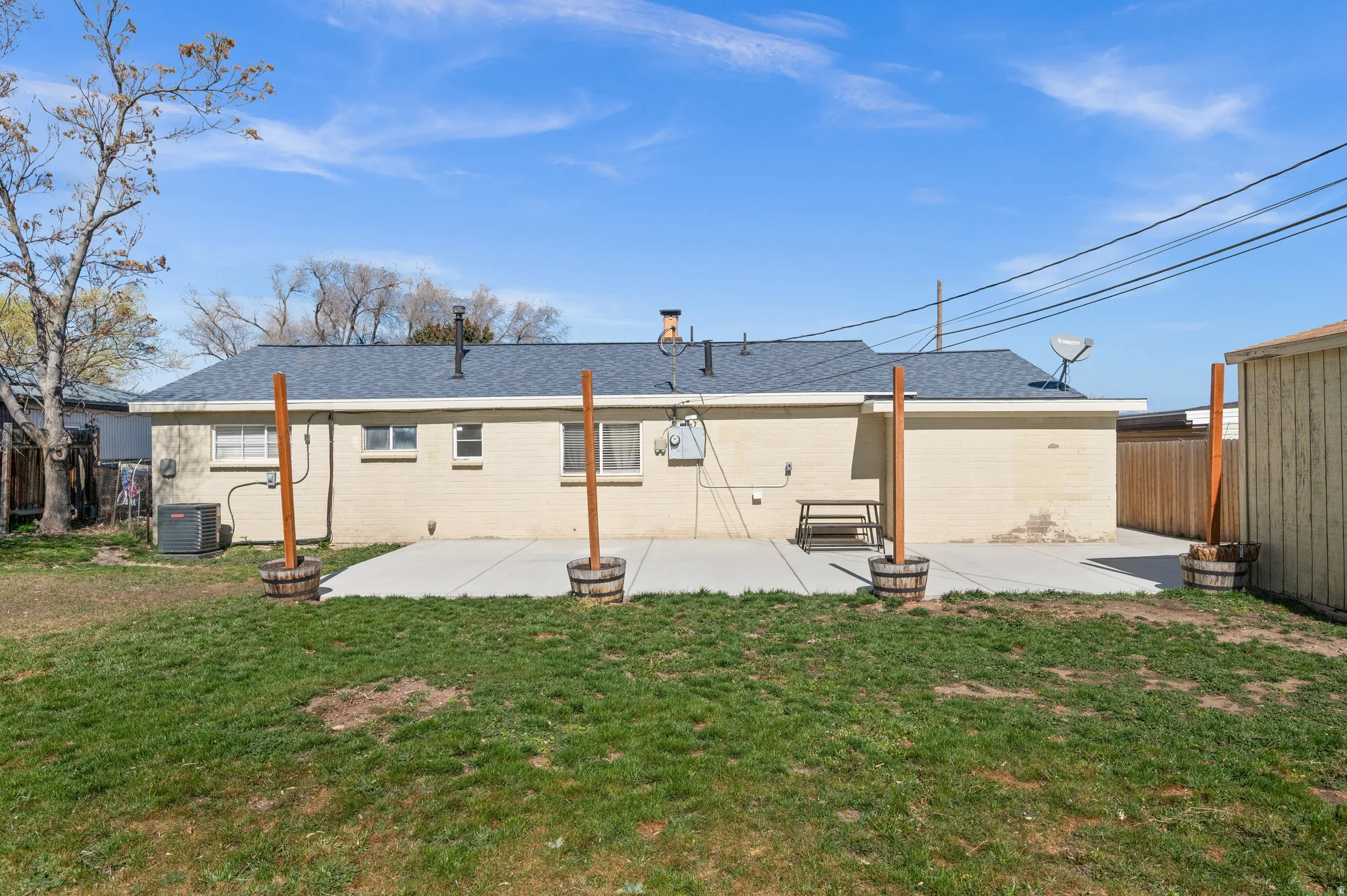 Rear view of property with a patio, a fenced backyard, roof with shingles, and brick siding