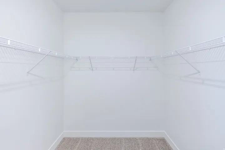 White wire shelving system, light-colored carpet, and crisp white walls