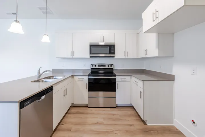 U-shaped kitchen with white cabinetry and light-toned countertops