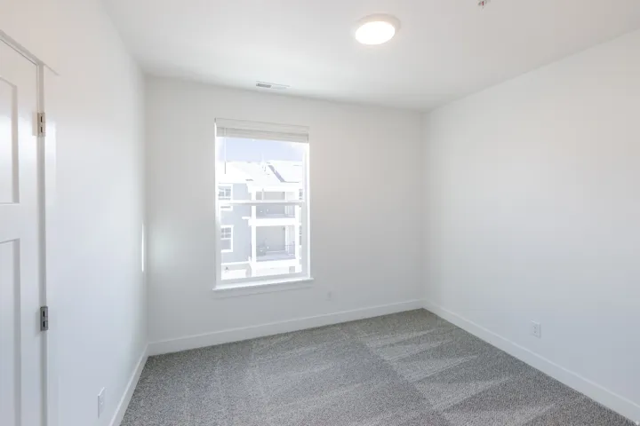 Recessed window with white trim, light gray wall-to-wall carpeting, white walls, and a flush mount ceiling light