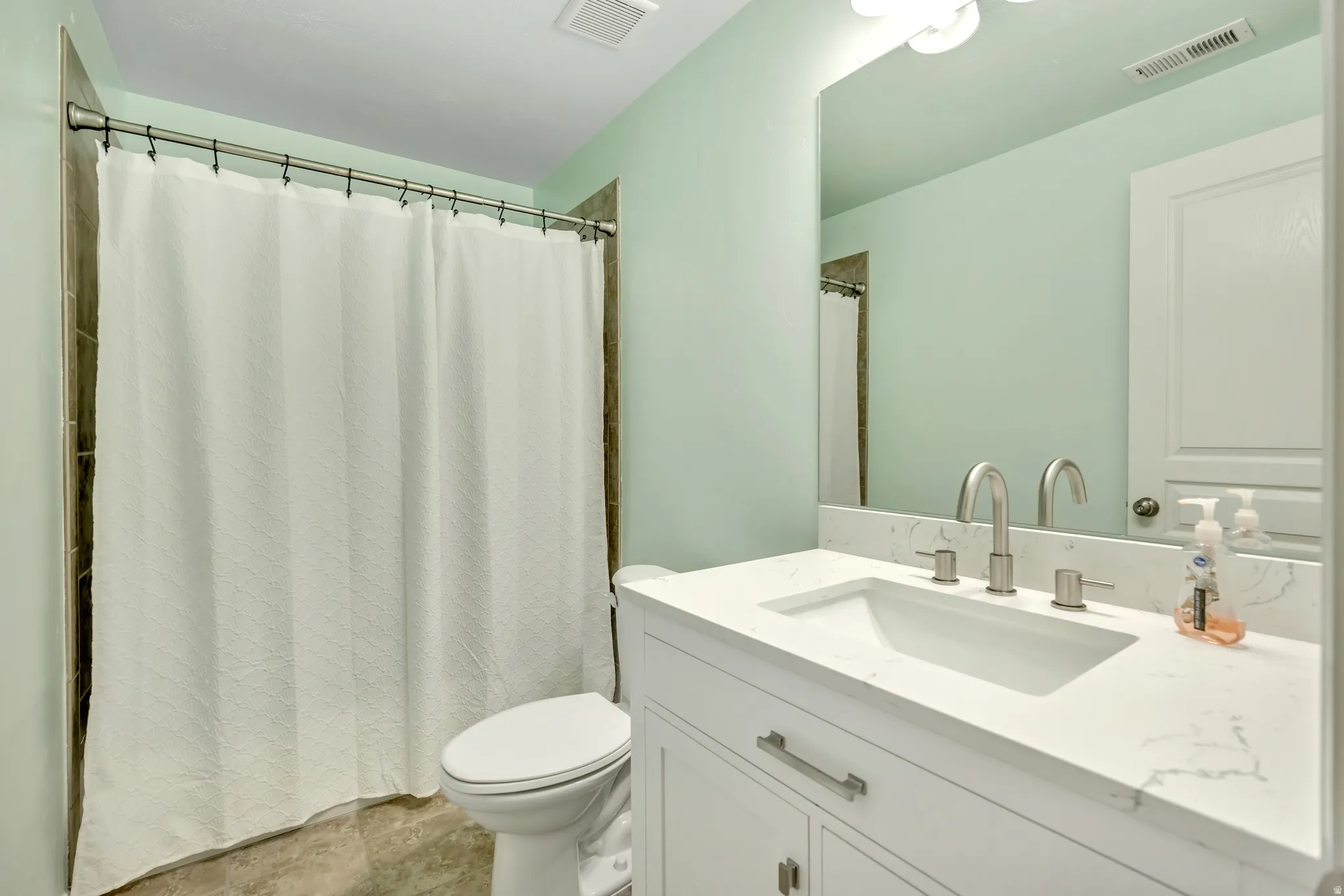 Bathroom with vanity and curtained shower