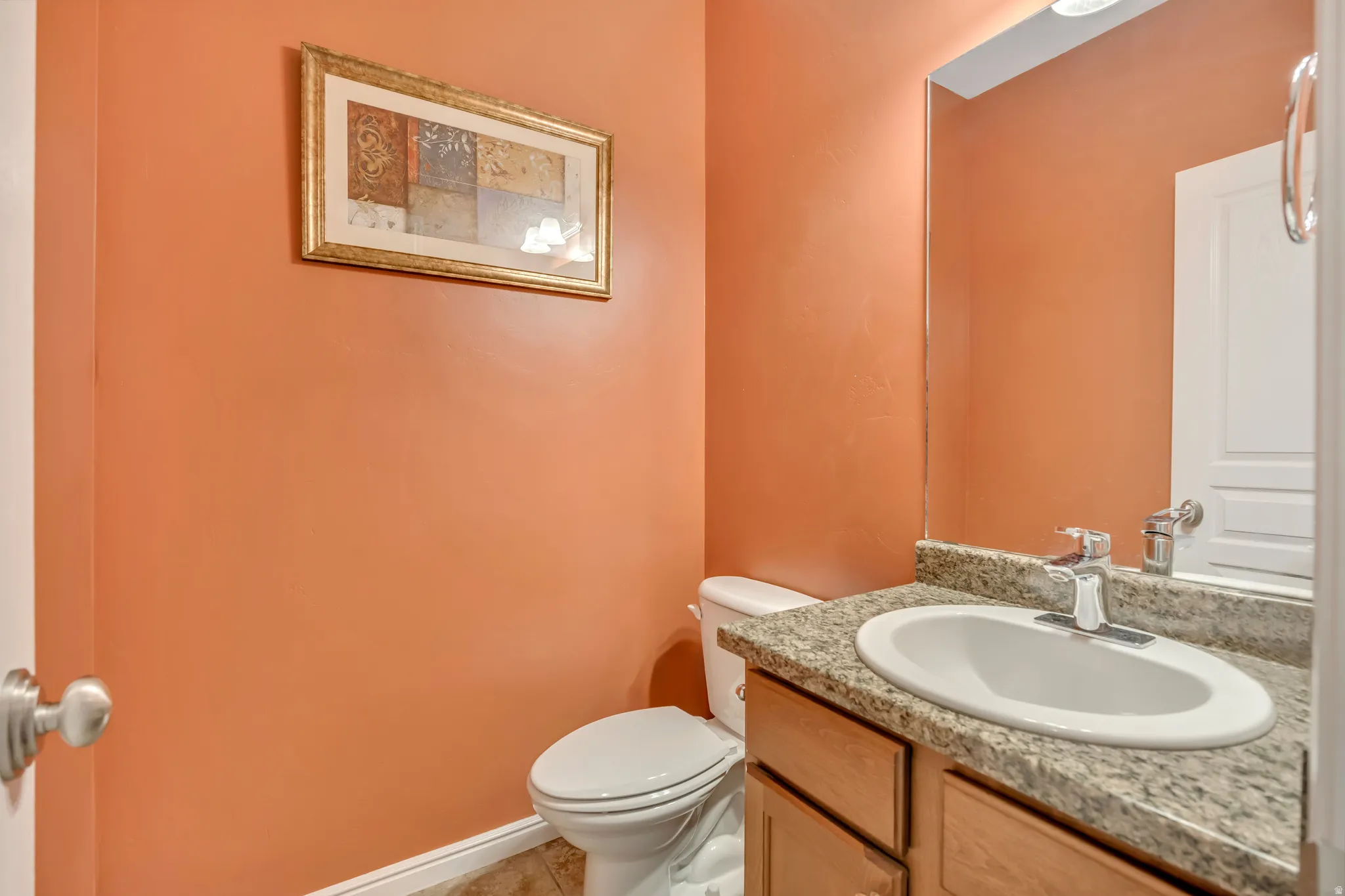 Half bathroom with vanity and light tile patterned floors
