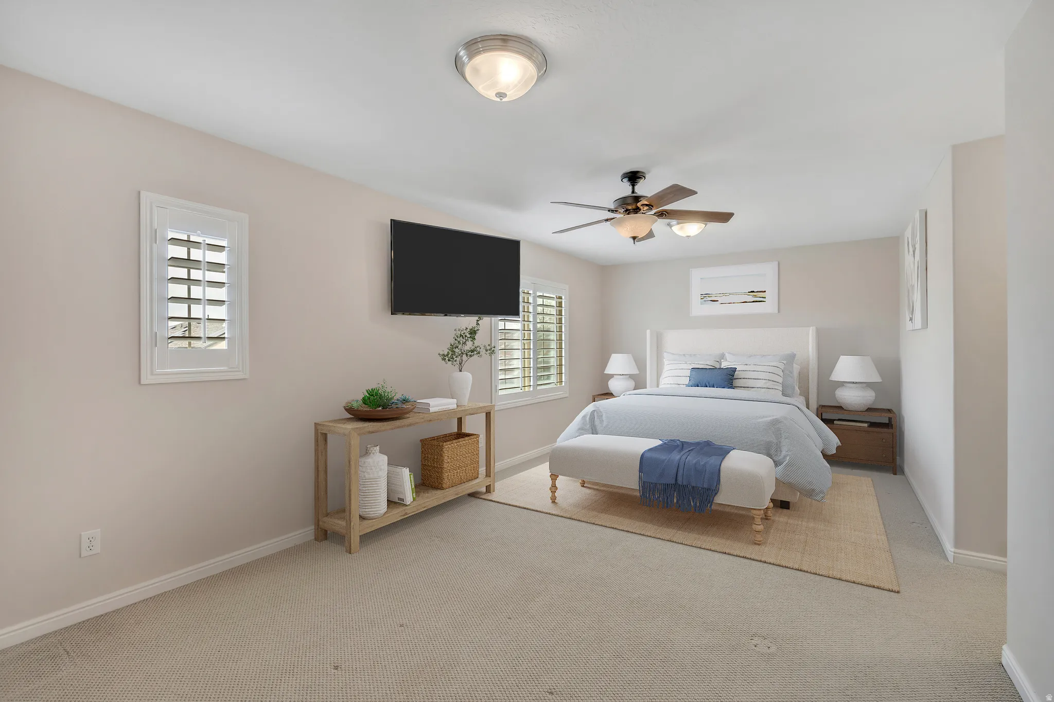 Owner's suite with light carpet and a ceiling fan