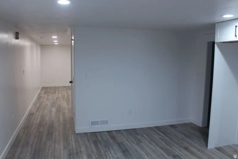 Spare room featuring recessed lighting and dark wood-style floors