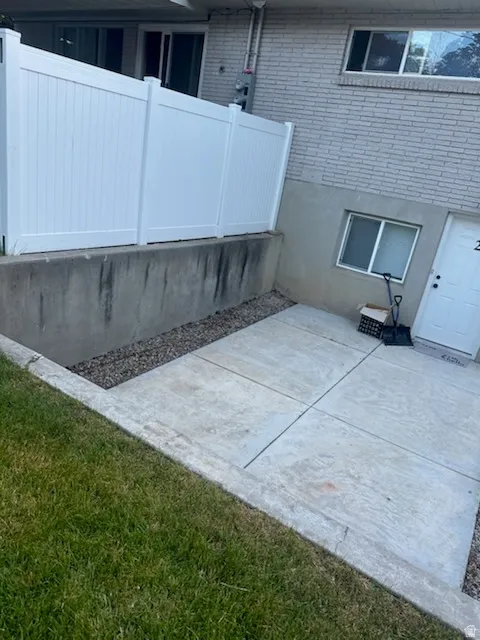 View of property exterior with a patio and brick siding