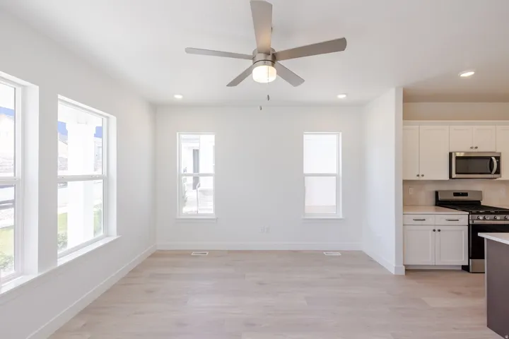 Open-concept living space featuring wood-finish flooring and ample natural light from multiple windows