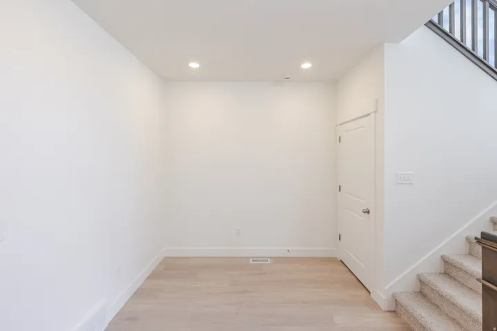 Open concept area featuring light wood-finish flooring, recessed ceiling lighting, and a neutral color palette