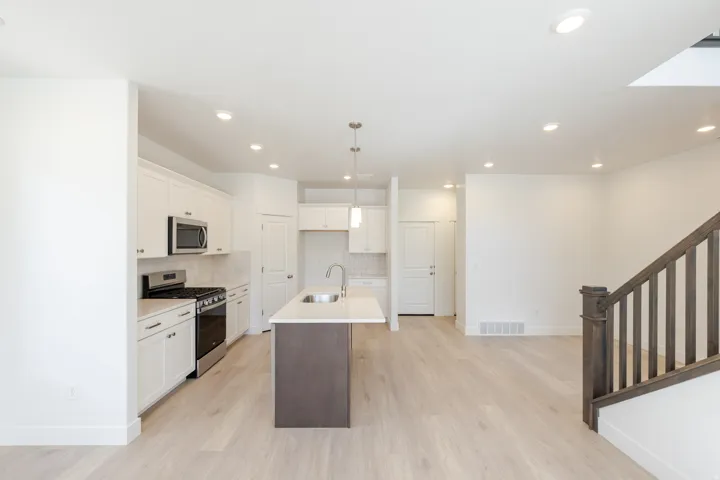 Open-concept kitchen and living area featuring light wood-finish flooring