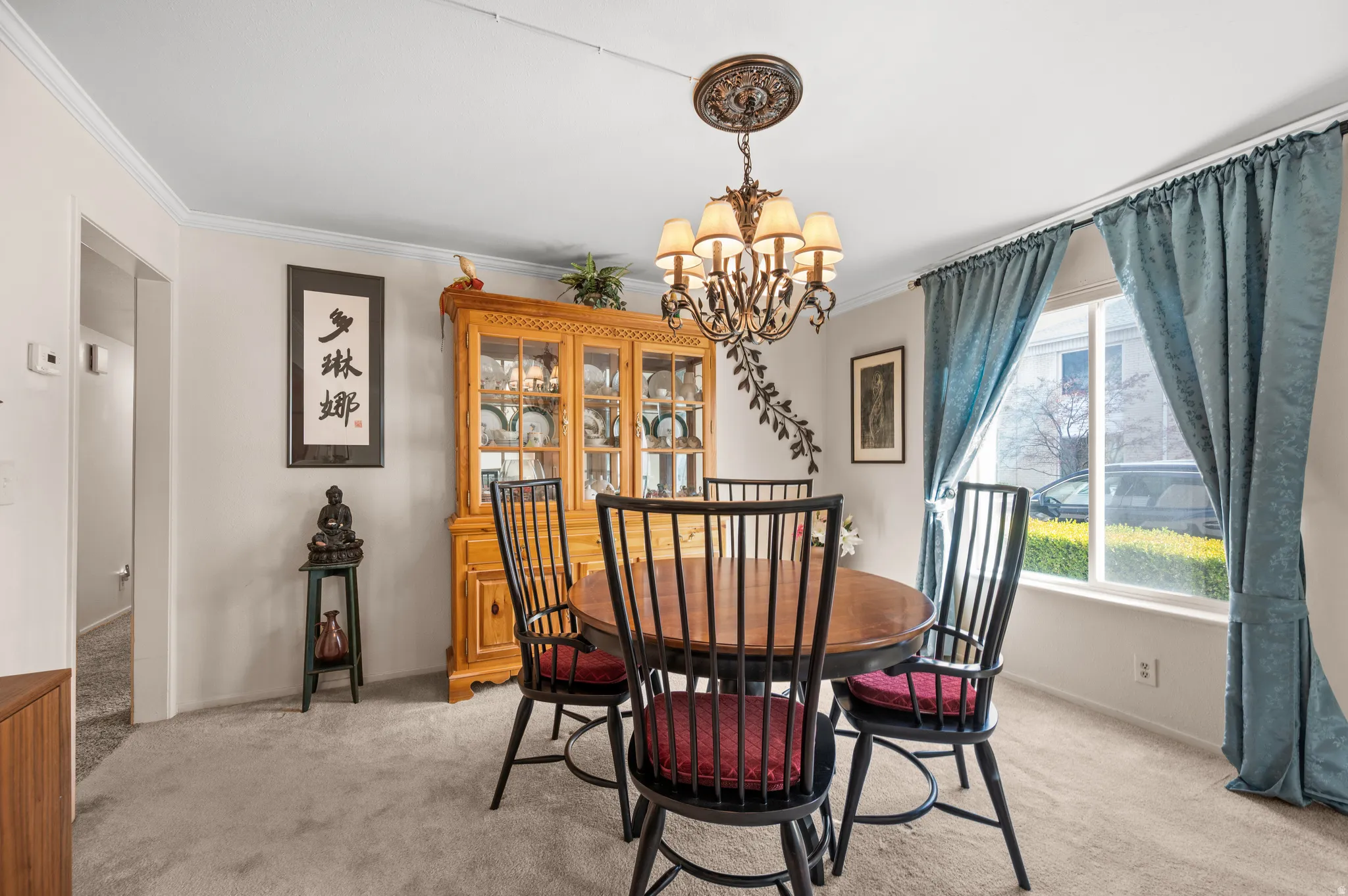 Dining space with light colored carpet, suspended lighting, and crown molding
