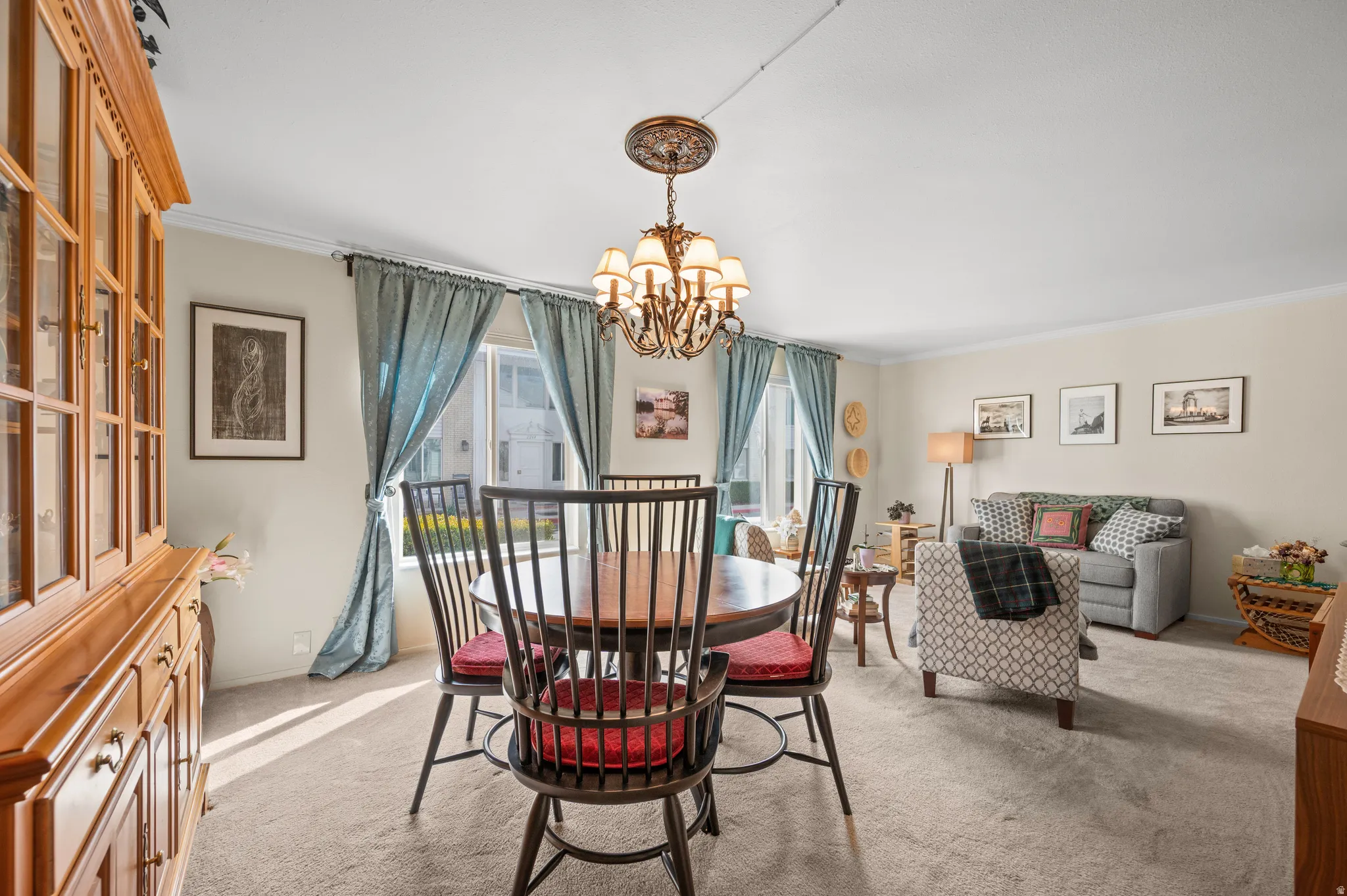 Dining area featuring hanging lights, carpet floors, and crown molding