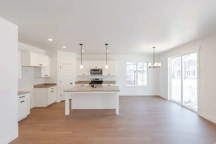 Open-concept kitchen and dining area featuring light wood-finish flooring