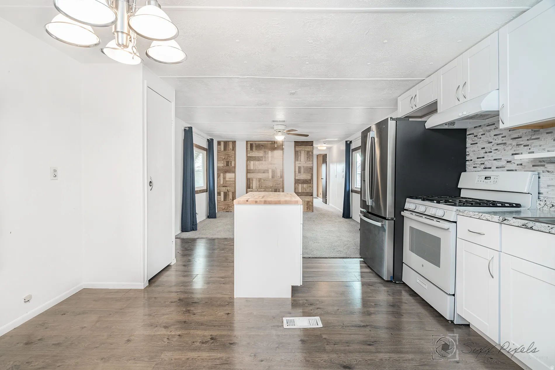 Kitchen with gas range gas stove, white cabinets, a center island, and plenty of natural light
