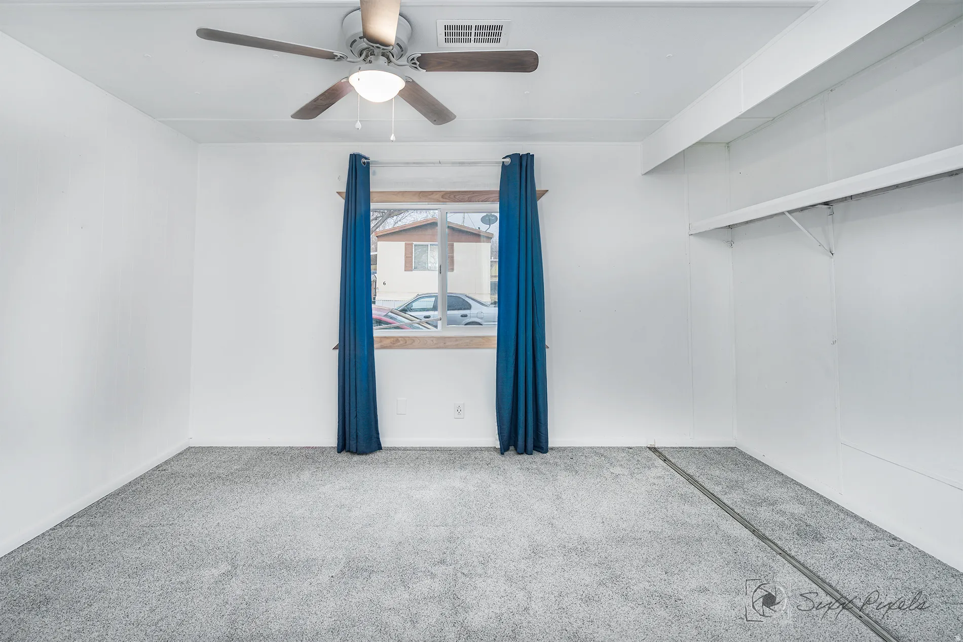 Carpeted spare room featuring a ceiling fan