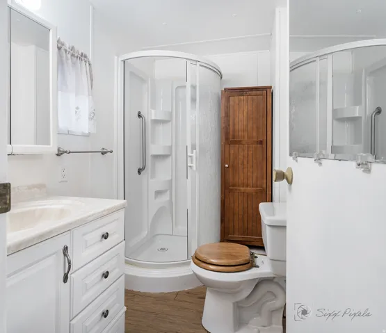 Bathroom with vanity, a shower stall, and dark wood finished floors