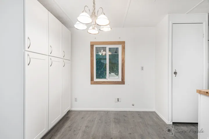 Unfurnished dining area featuring a chandelier and dark wood-type flooring