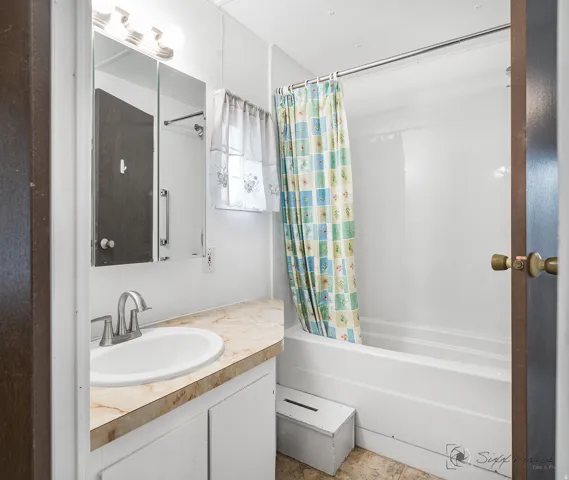 Bathroom with vanity and shower / tub combo