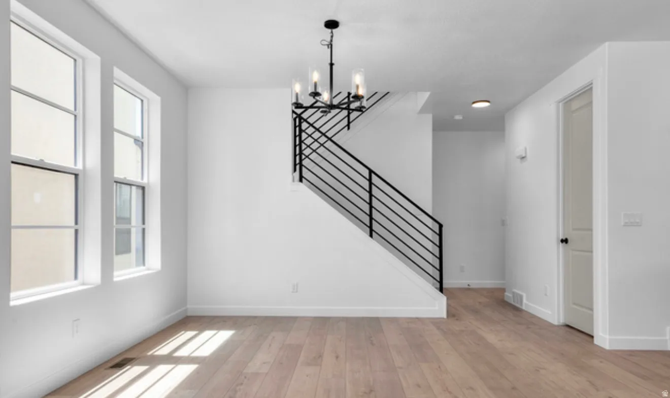 Unfurnished dining area featuring light wood-style flooring and hanging lights