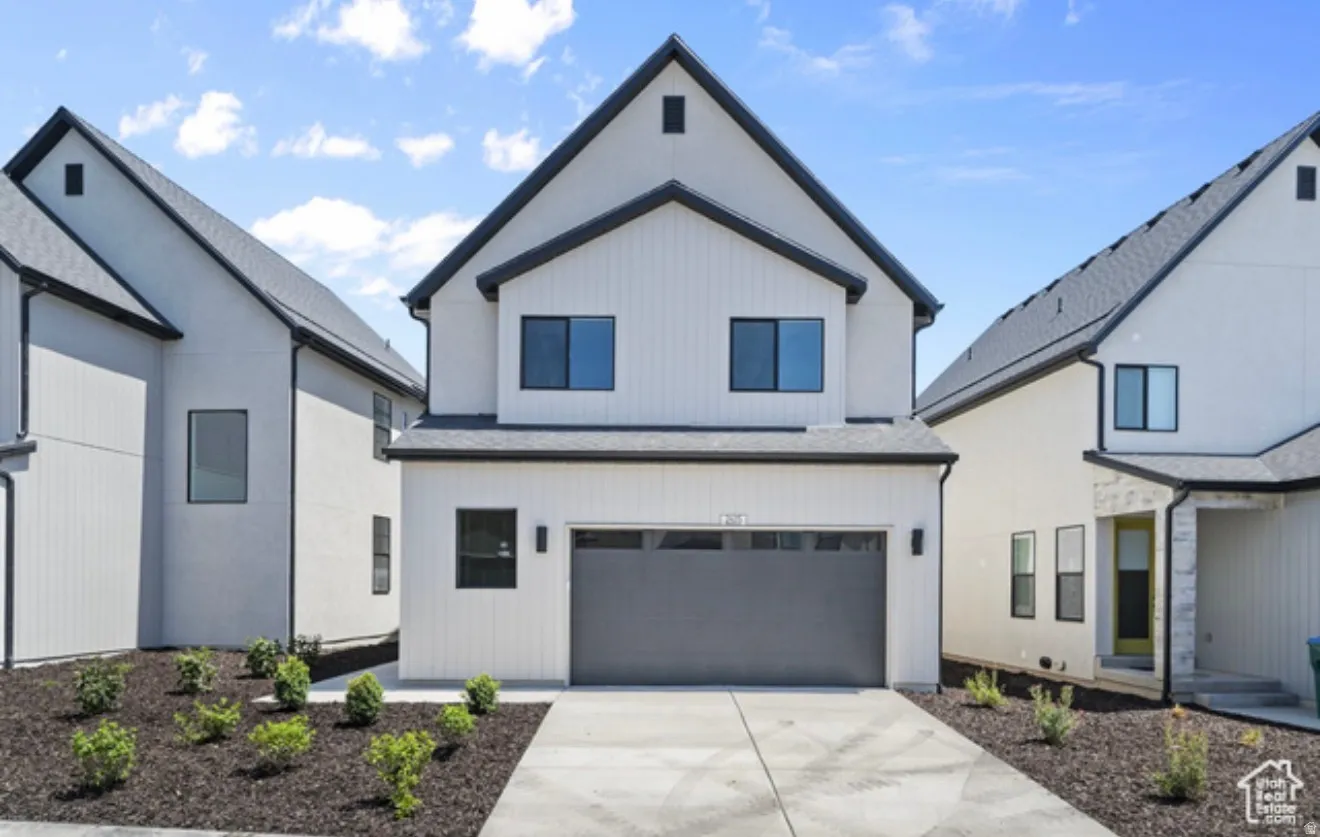 Modern farmhouse with an attached garage, concrete driveway, and a shingled roof
