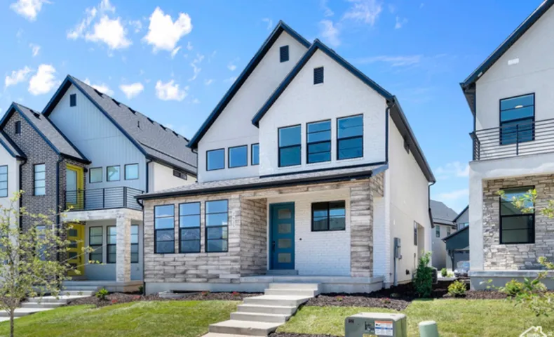 View of front facade featuring stone siding and a front yard