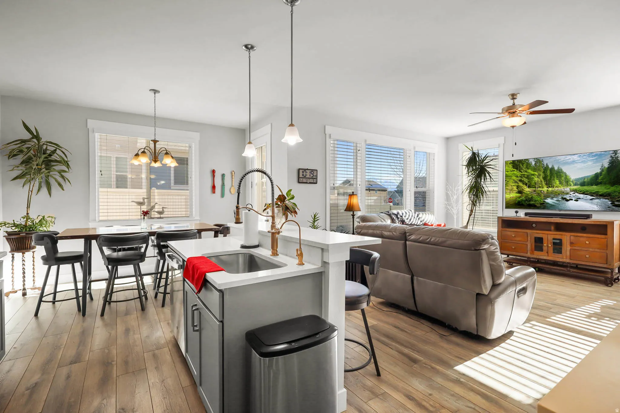 Kitchen with a kitchen breakfast bar, dark wood-style flooring, open floor plan, a ceiling fan, and gray cabinetry