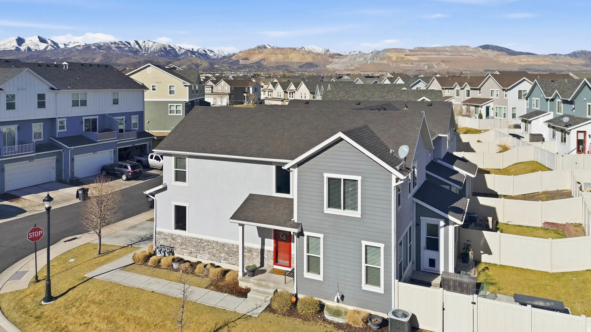 Traditional home featuring a residential view, roof with shingles, a mountain view, a gate, and stone siding