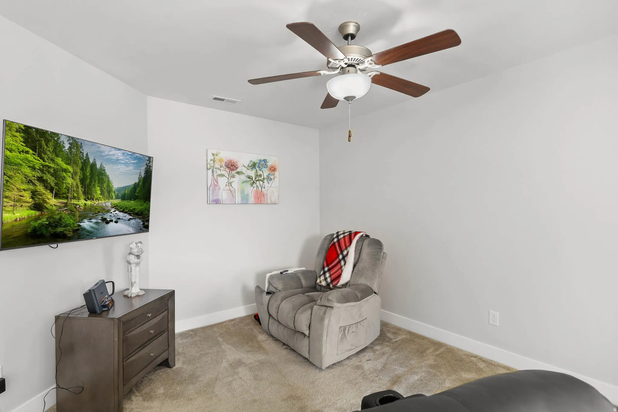 Living area featuring light carpet and ceiling fan