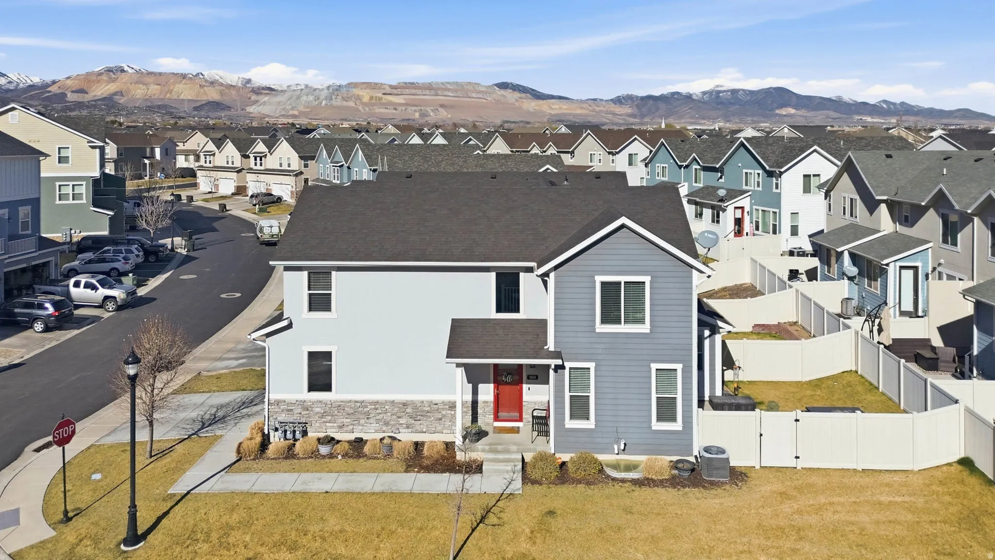 View of front of property with a gate, a mountain view, a shingled roof, a residential view, and stone siding