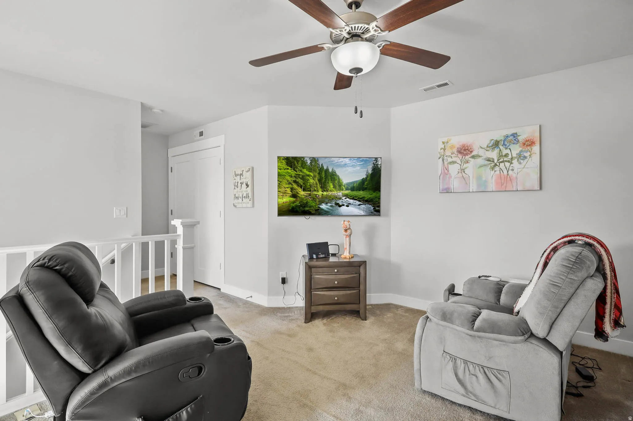 Living area with light colored carpet and ceiling fan