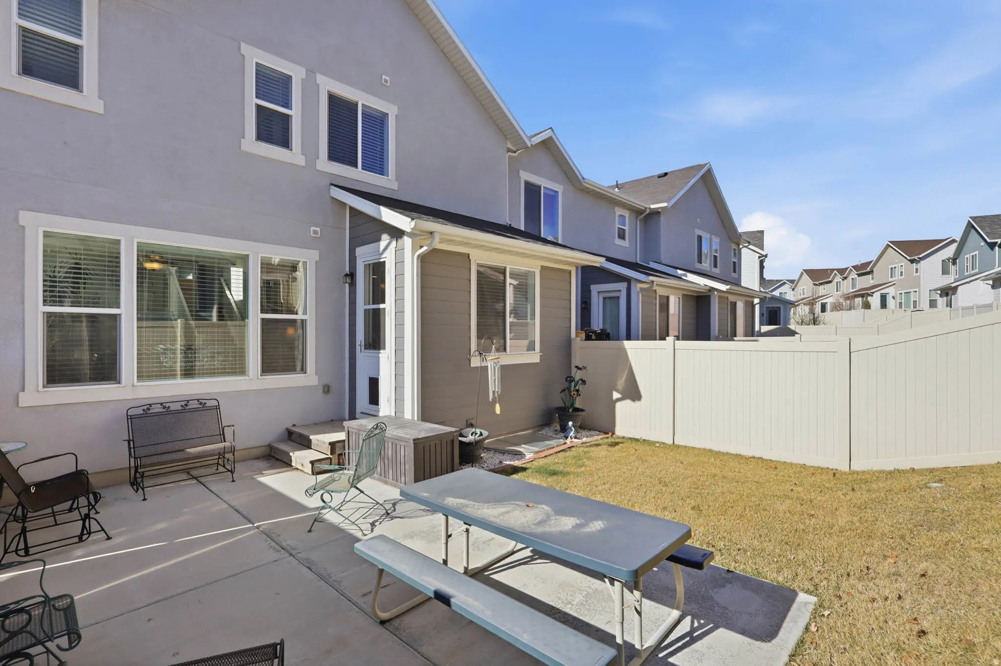 Back of property with a residential view, a patio, and stucco siding