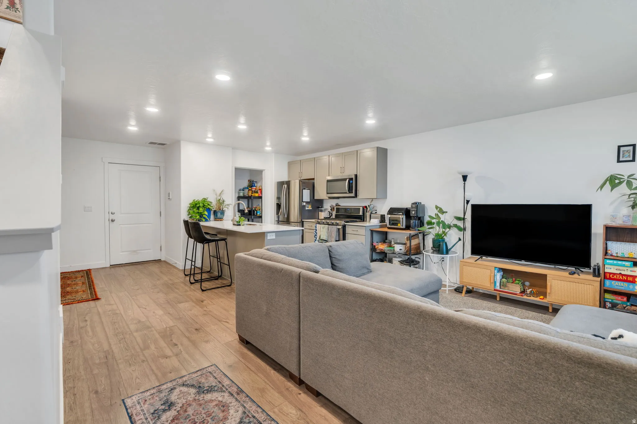 Living area with light wood-style floors and recessed lighting