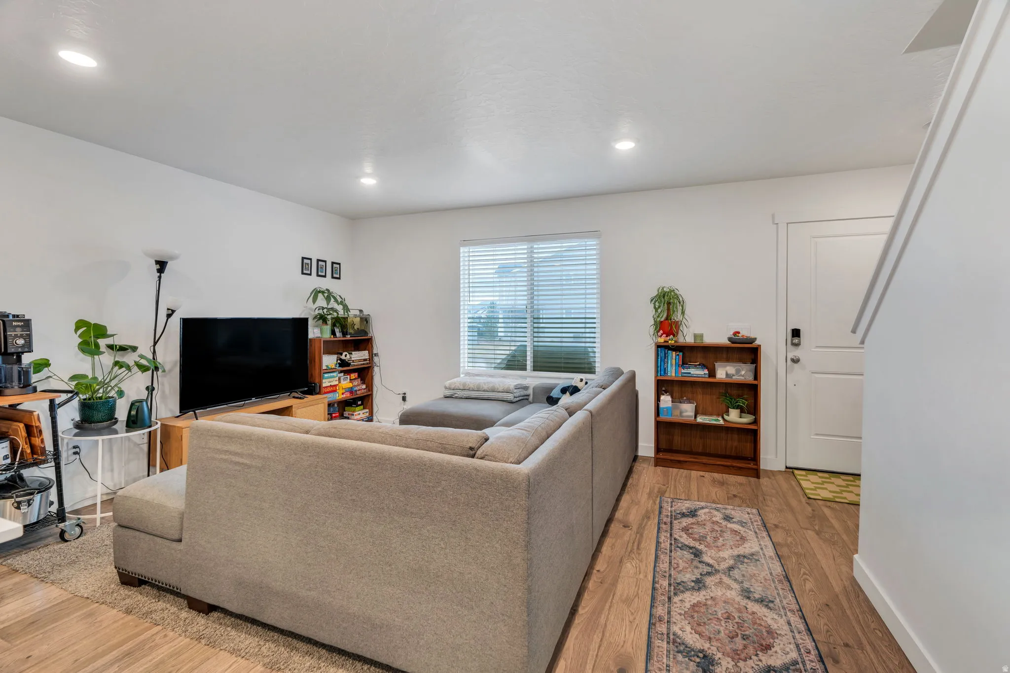 Living room with light wood finished floors and recessed lighting