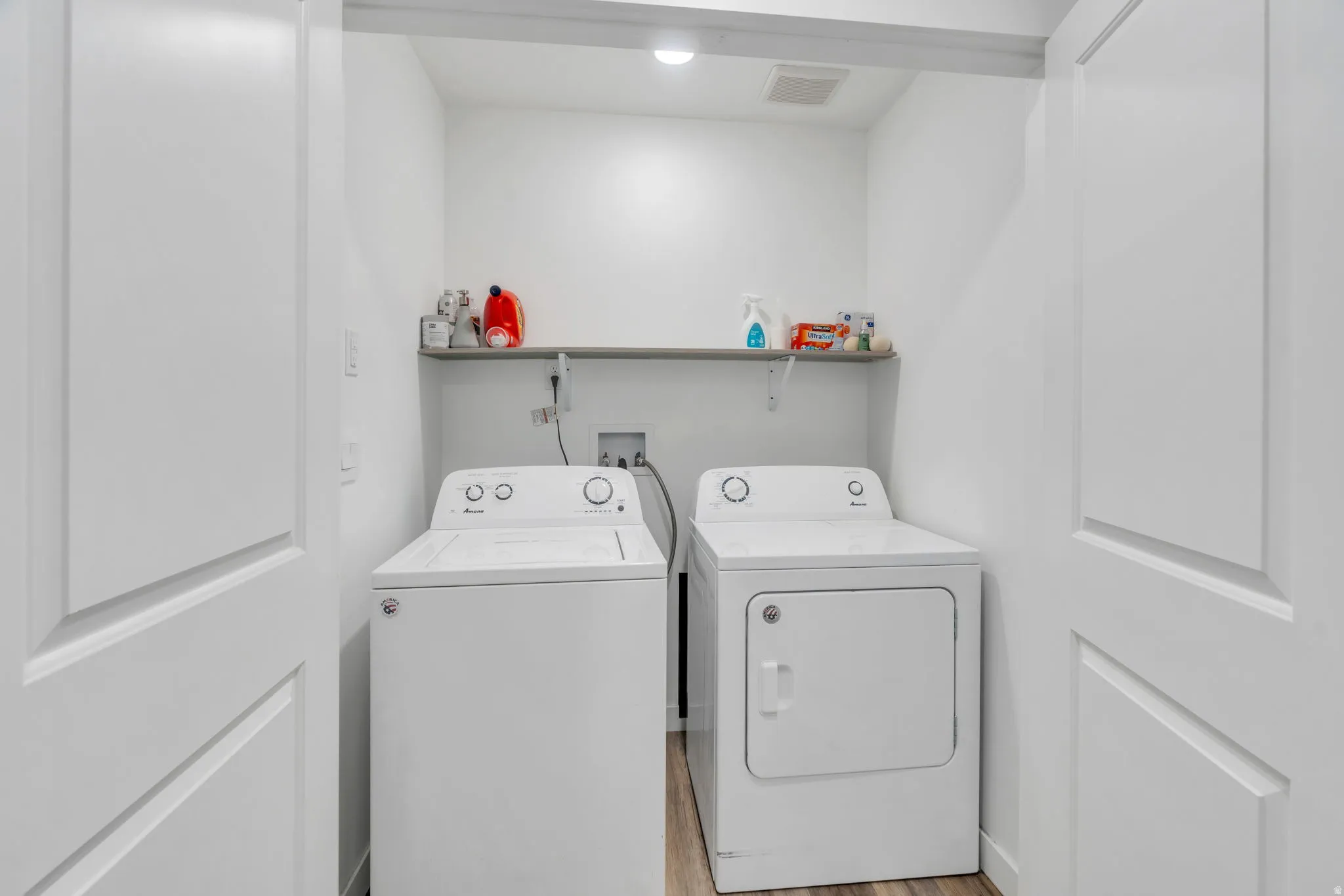 Laundry area featuring separate washer and dryer and light wood-type flooring