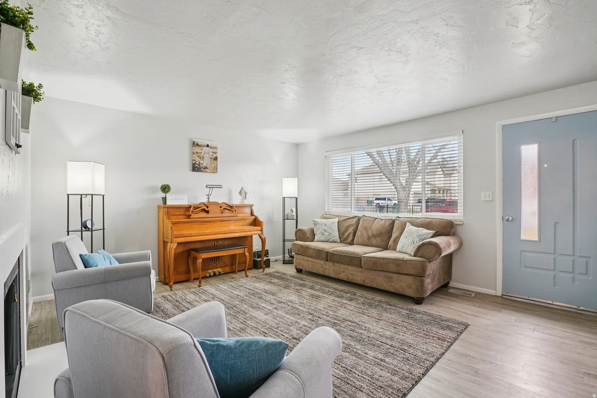 Living room with light wood-type flooring and a textured ceiling
