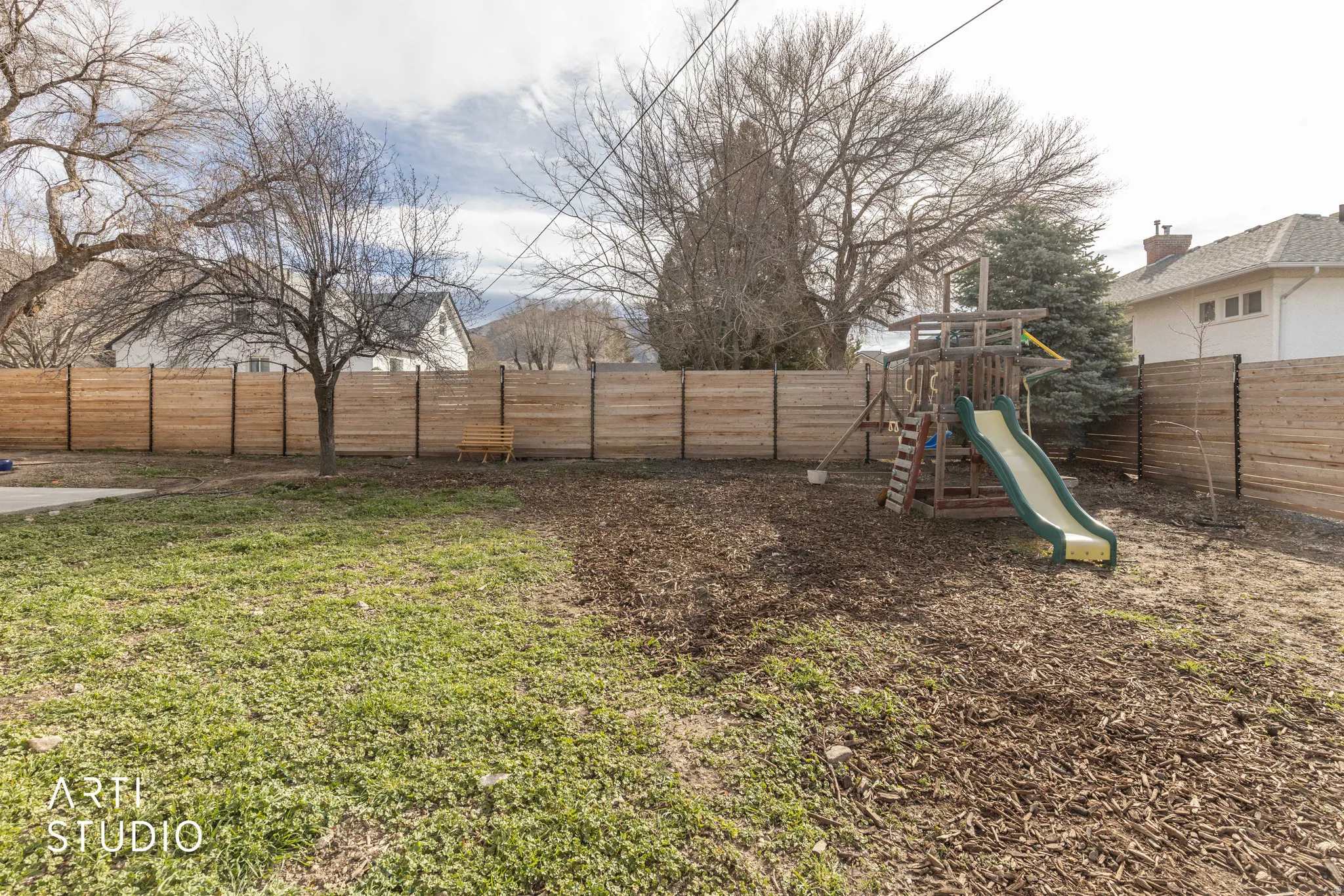 Fenced backyard with a playground