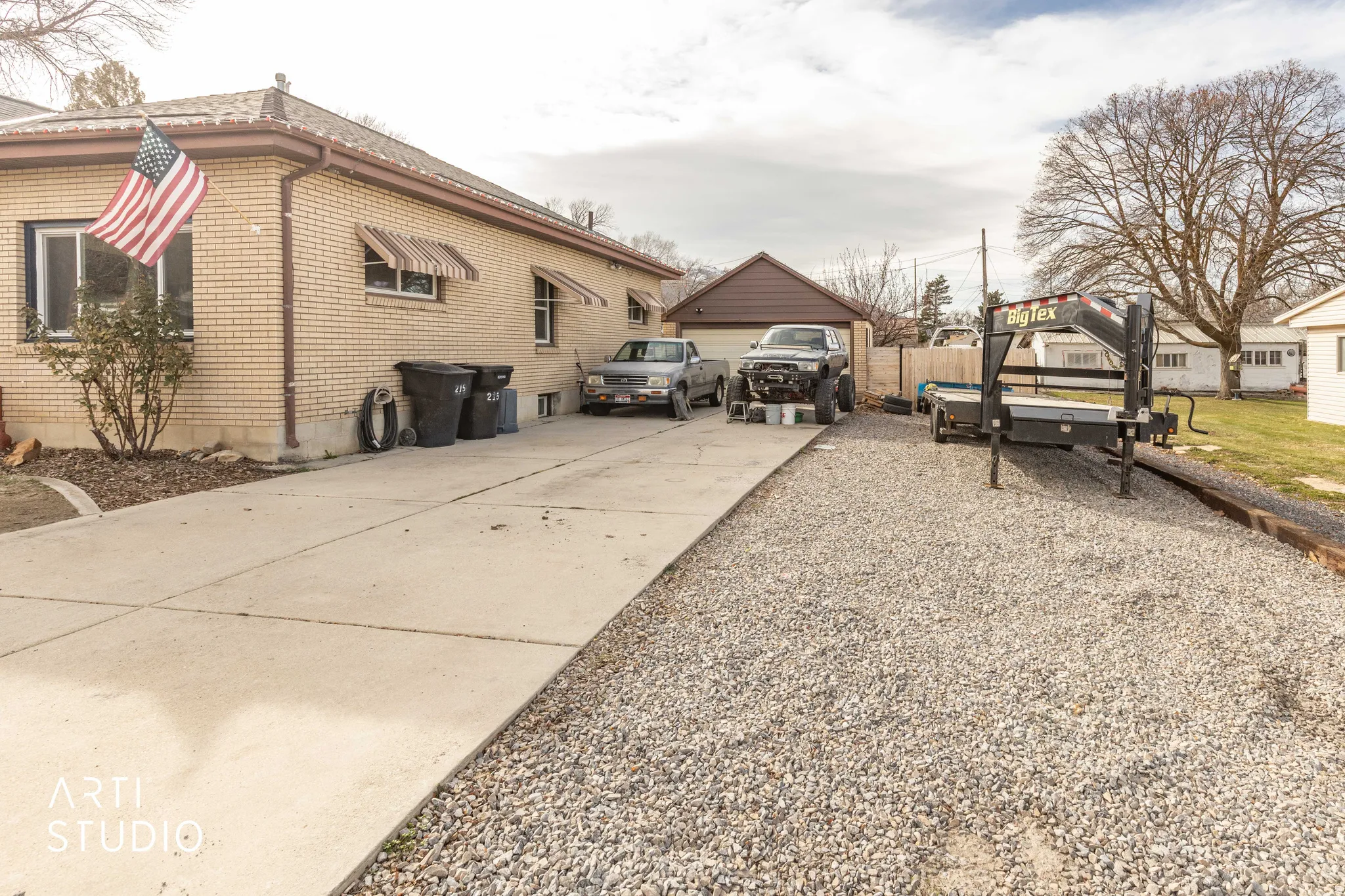 View of side of home featuring concrete driveway and brick siding