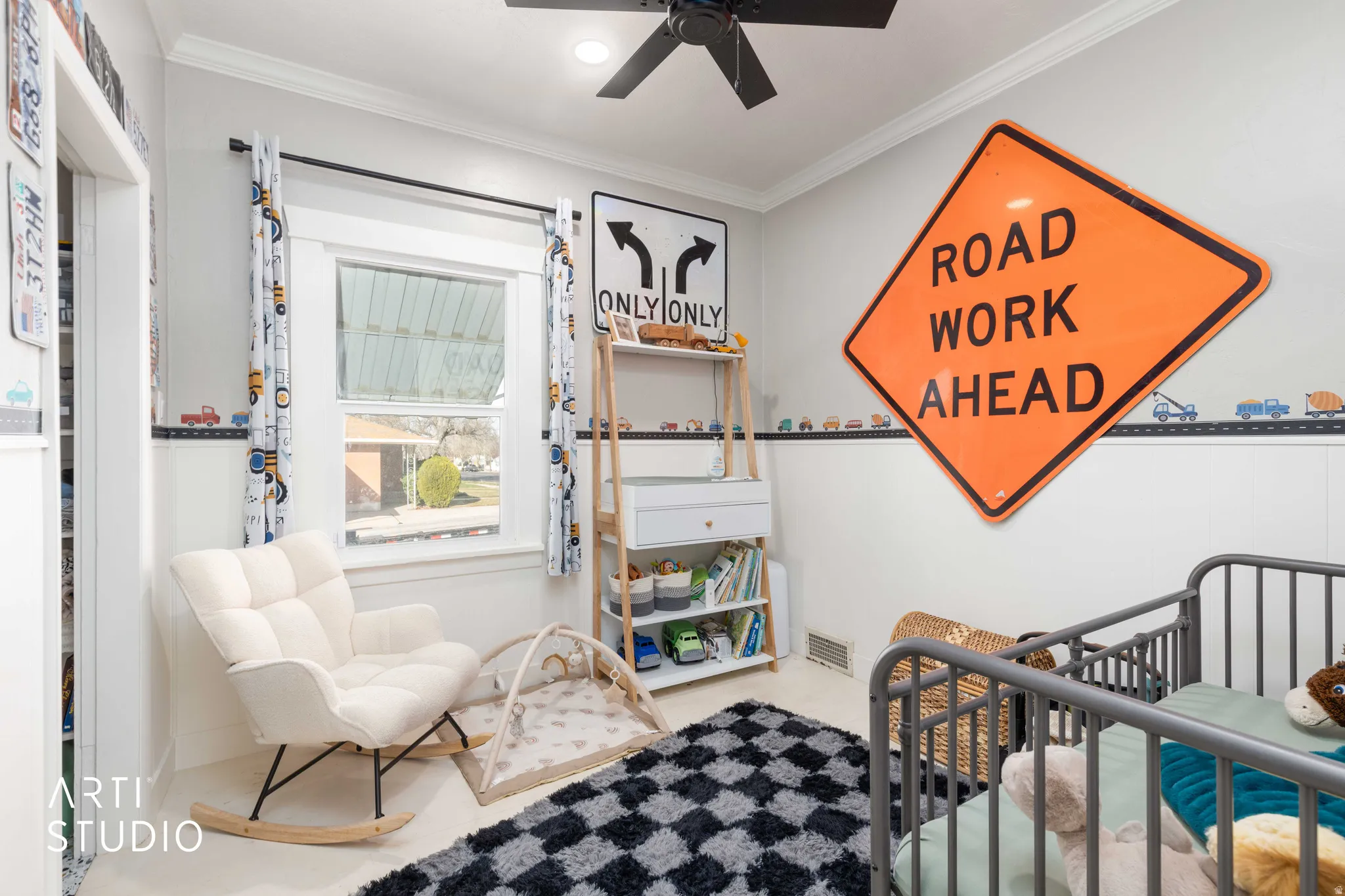Bedroom featuring crown molding, a crib, and ceiling fan