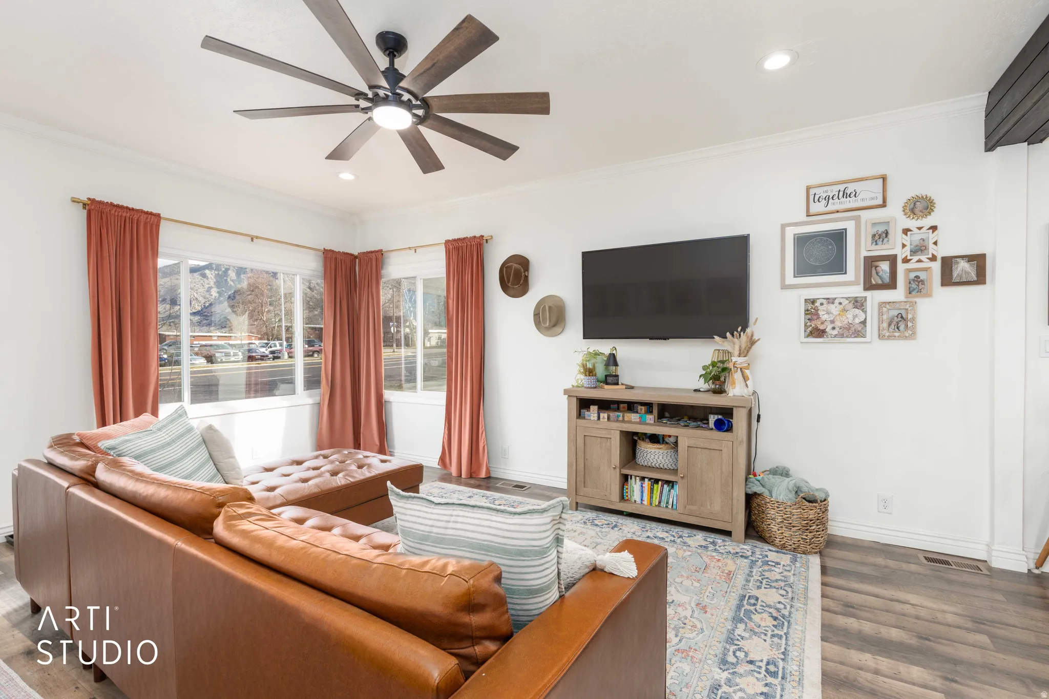 Living room featuring dark wood-type flooring, recessed lighting, ornamental molding, and a ceiling fan