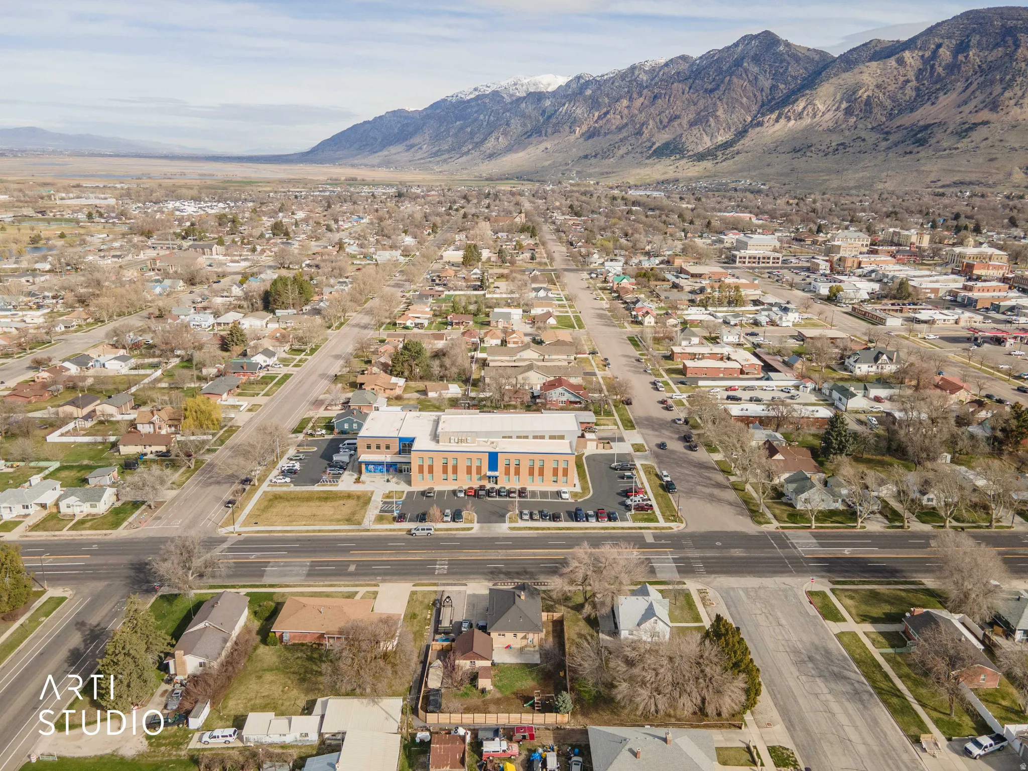 Aerial view of property and surrounding area with mountains and nearby suburban area