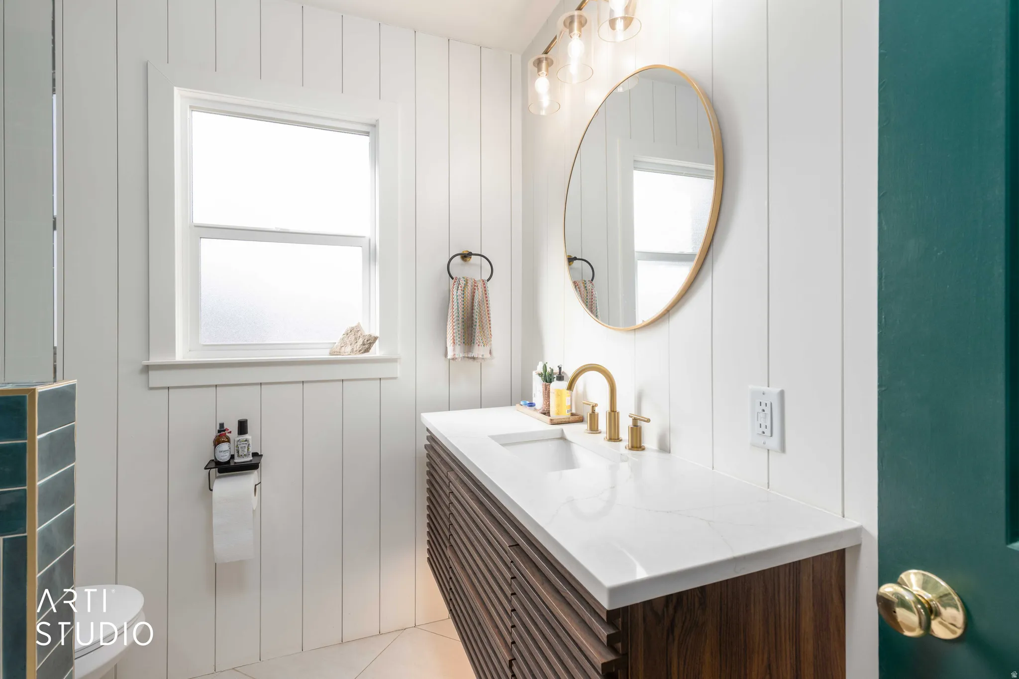 Bathroom featuring vanity, light tile patterned floors, and wood walls