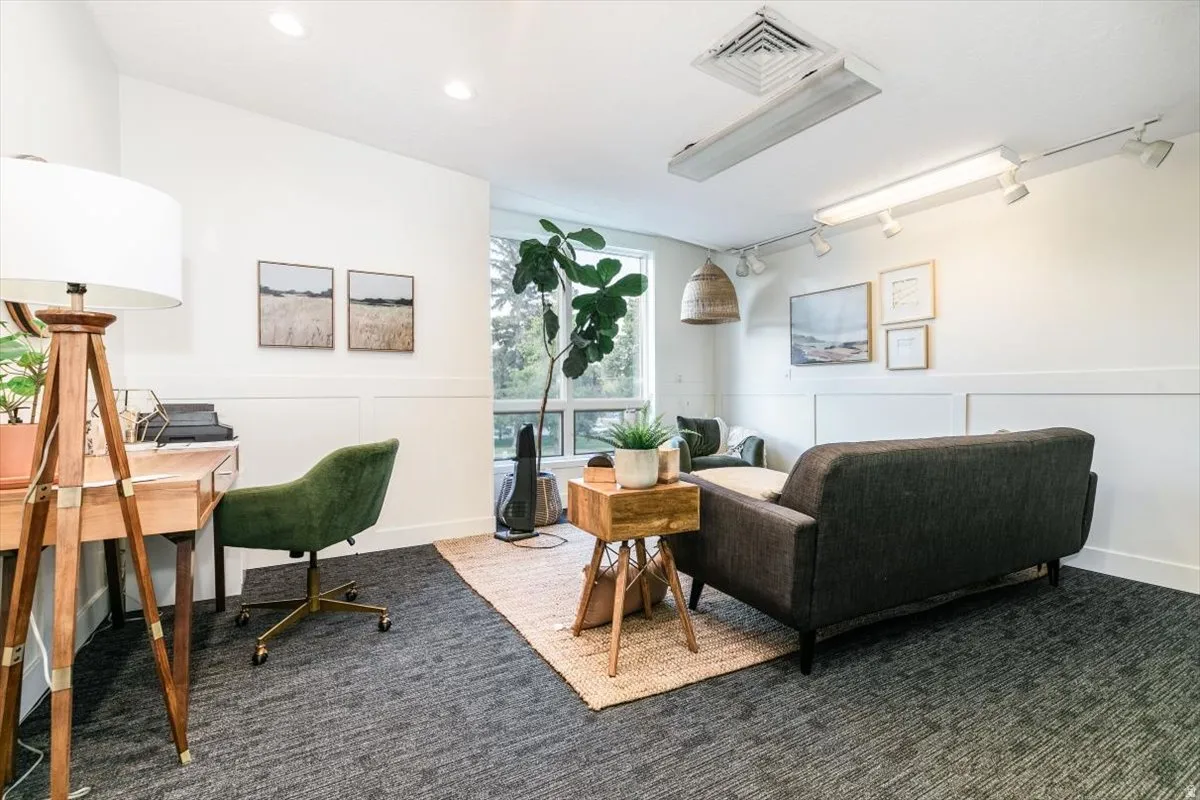 Office with track lighting, a decorative wall, and wainscoting