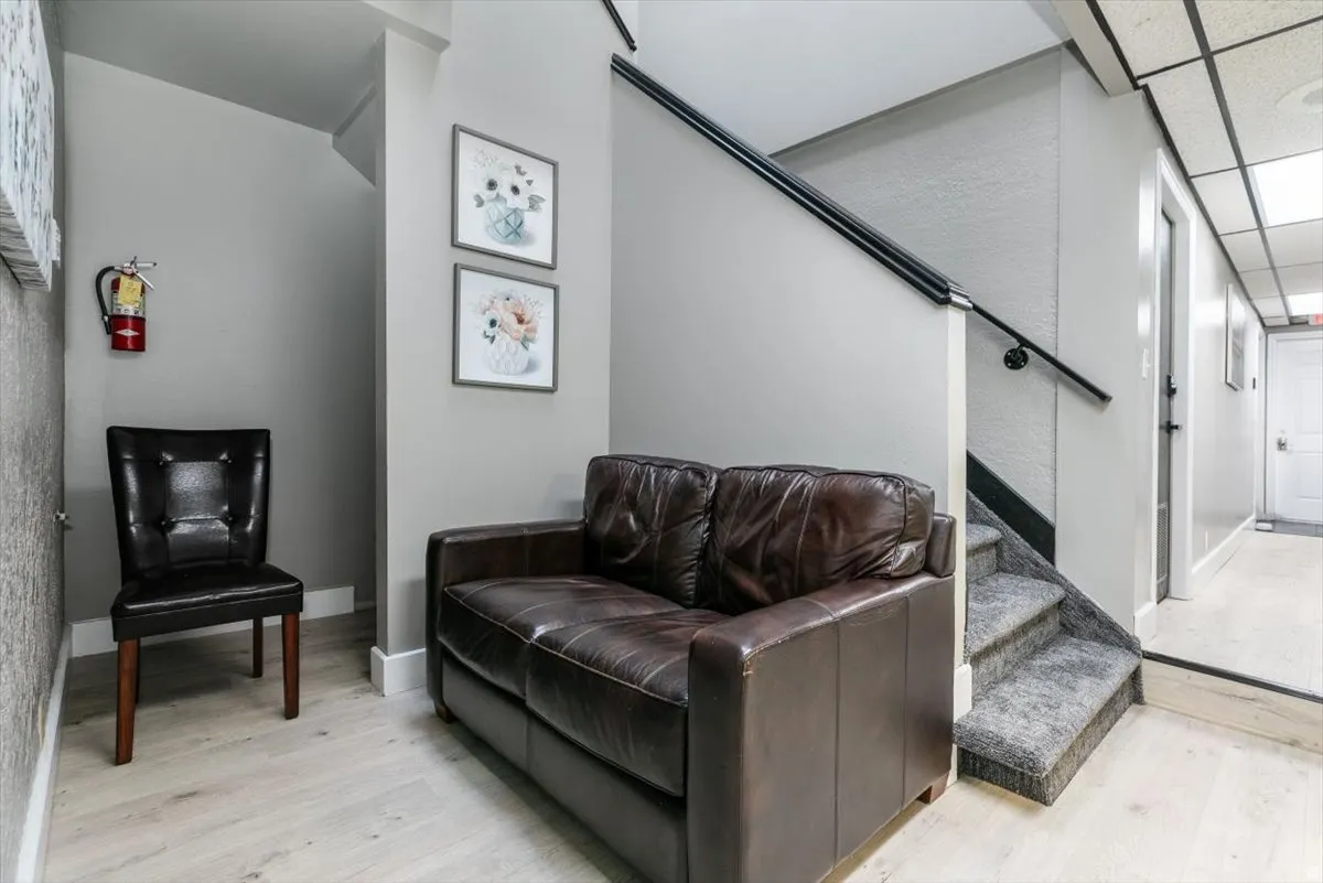 Living area featuring light wood finished floors and a drop ceiling