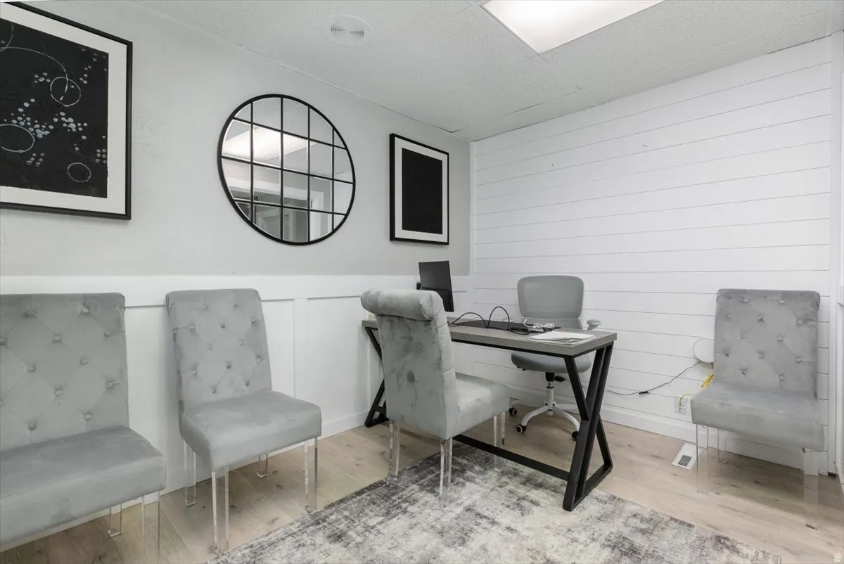 Office with wood finished floors and a wainscoted wall