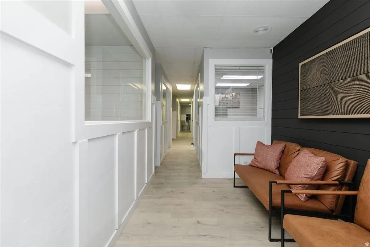 Corridor featuring light wood-style floors and wooden walls
