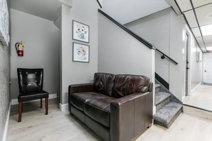 Living area featuring light wood finished floors and a drop ceiling