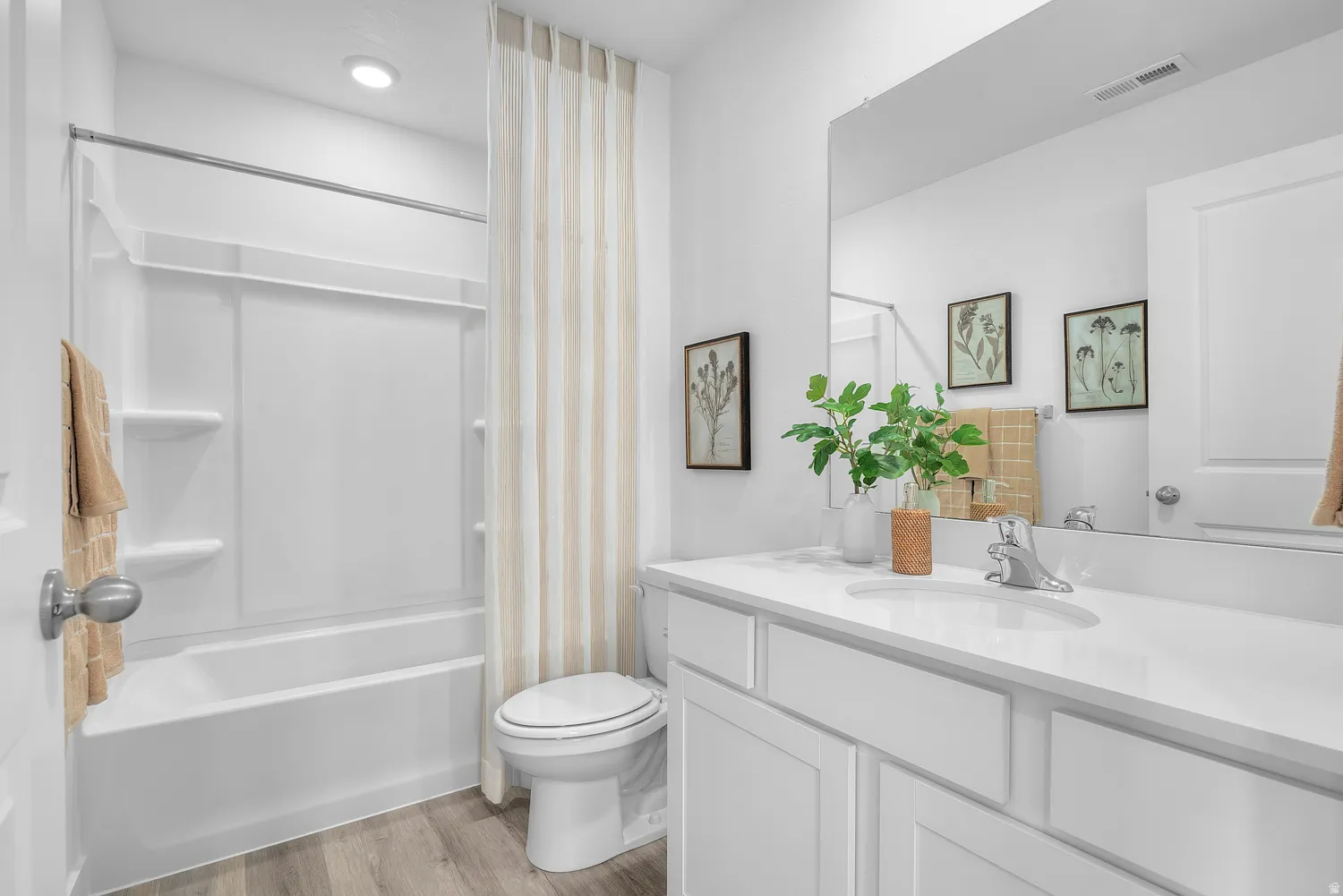Full bathroom with vanity, light wood-style flooring, and shower / bath combination with curtain