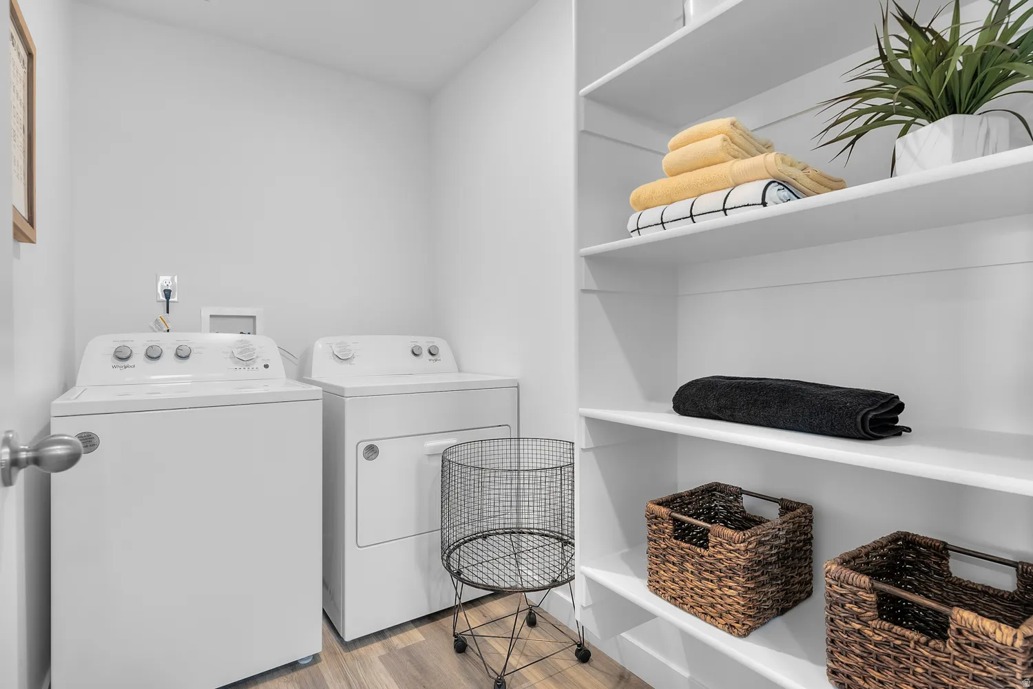 Laundry area with light wood-style flooring and washing machine and dryer
